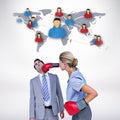 Composite image of businesswoman punching colleague with boxing gloves Royalty Free Stock Photo