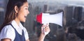 Composite image of businesswoman shooting through a megaphone