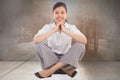 Composite image of businesswoman sitting cross legged with hands together