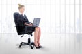 Composite image of businesswoman sitting on swivel chair with laptop