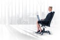 Composite image of businesswoman sitting on swivel chair with laptop