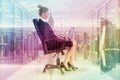 Composite image of businesswoman sitting on swivel chair with laptop