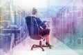 Composite image of businesswoman sitting on swivel chair with tablet