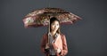 Composite image of businesswoman with an umbrella holding a binder