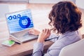 Composite image of businesswoman using laptop at desk in creative office Royalty Free Stock Photo