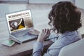 Composite image of businesswoman using laptop at desk in creative office Royalty Free Stock Photo