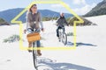 Composite image of carefree couple going on a bike ride on the beach Royalty Free Stock Photo