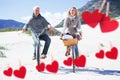 Composite image of carefree couple going for a bike ride and picnic on the beach Royalty Free Stock Photo