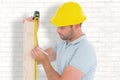 Composite image of carpenter using measure tape to mark on wooden plank Royalty Free Stock Photo
