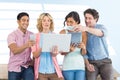 Composite image of casual businesspeople using digital tablet with colleagues behind in office Royalty Free Stock Photo