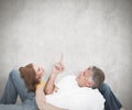 Composite image of casual couple lying on floor Royalty Free Stock Photo