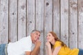 Composite image of casual couple lying on floor Royalty Free Stock Photo