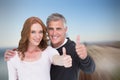 Composite image of casual couple showing thumbs up Royalty Free Stock Photo