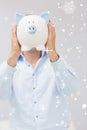 Composite image of casual man holding piggy bank in front of his face Royalty Free Stock Photo