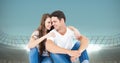 Composite image of caucasian couple embracing each other against sports stadium with copy space Royalty Free Stock Photo