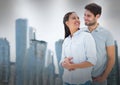 Composite image of caucasian couple embracing each other against tall buildings in background Royalty Free Stock Photo