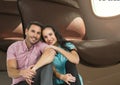 Composite image of caucasian couple smiling against airplane window in background