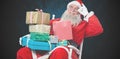 Composite image of cheerful santa claus holding chritmas presents while sitting on chair Royalty Free Stock Photo