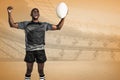Composite image of cheerful sportsman with clenched fist holding rugby ball Royalty Free Stock Photo