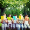 Composite image of children reading books at park Royalty Free Stock Photo