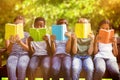 Composite image of children reading books at park Royalty Free Stock Photo