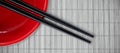 Composite image of close up of chopstick with red bowl Royalty Free Stock Photo