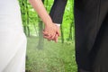 Composite image of close up of cute young newlyweds holding their hands