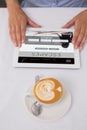 Composite image of close-up of digital tablet and coffee on table Royalty Free Stock Photo