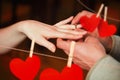 Composite image of close up on man putting on ring during marriage proposal