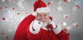 Composite image of close-up portrait of santa claus pointing while carrying christmas bag Royalty Free Stock Photo