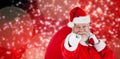 Composite image of close-up portrait of santa claus pointing while carrying christmas bag Royalty Free Stock Photo