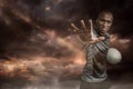 Composite image of close-up portrait of sportsman gesturing while standing with rugby ball Royalty Free Stock Photo