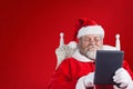 Composite image of close-up of santa claus holding digital tablet on armchair Royalty Free Stock Photo