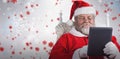 Composite image of close-up of santa claus holding digital tablet on armchair Royalty Free Stock Photo