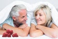 Composite image of closeup of a mature couple lying in bed Royalty Free Stock Photo