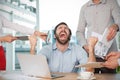 Composite image of colleagues standing by frustrated businessman at desk Royalty Free Stock Photo