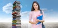 Composite image of college girl holding books with blurred students in park