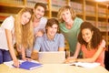 Composite image of college students using laptop in library Royalty Free Stock Photo