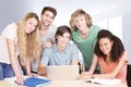 Composite image of college students using laptop in library Royalty Free Stock Photo