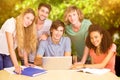 Composite image of college students using laptop in library Royalty Free Stock Photo