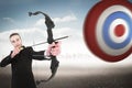 Composite image of concentrated businessman shooting a bow and arrow Royalty Free Stock Photo