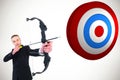 Composite image of concentrated businessman shooting a bow and arrow Royalty Free Stock Photo