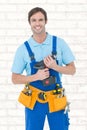Composite image of confident carpenter holding drill machine Royalty Free Stock Photo