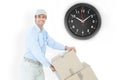 Composite image of confident delivery man pushing trolley of cardboard boxes Royalty Free Stock Photo