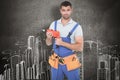 Composite image of confident male carpenter in overall holding drill machine Royalty Free Stock Photo