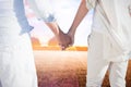 Composite image of couple on the beach looking out to sea holding hands Royalty Free Stock Photo