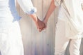 Composite image of couple on the beach looking out to sea holding hands Royalty Free Stock Photo