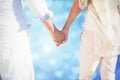 Composite image of couple on the beach looking out to sea holding hands Royalty Free Stock Photo