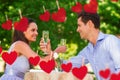 Composite image of couple with champagne flutes sitting at outdoor cafÃÂ© Royalty Free Stock Photo