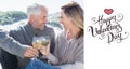 Composite image of couple enjoying white wine on picnic at the beach Royalty Free Stock Photo